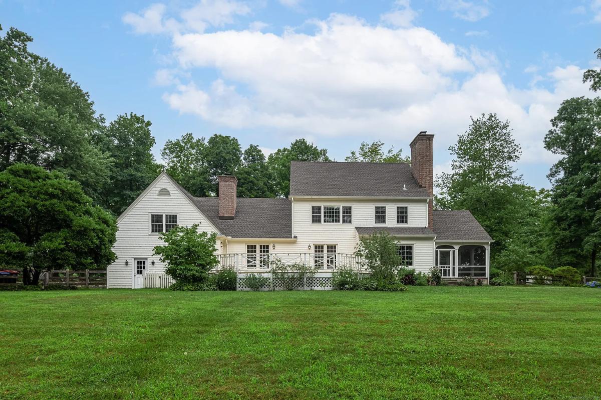 Rear view of the house with a large green lawn.
