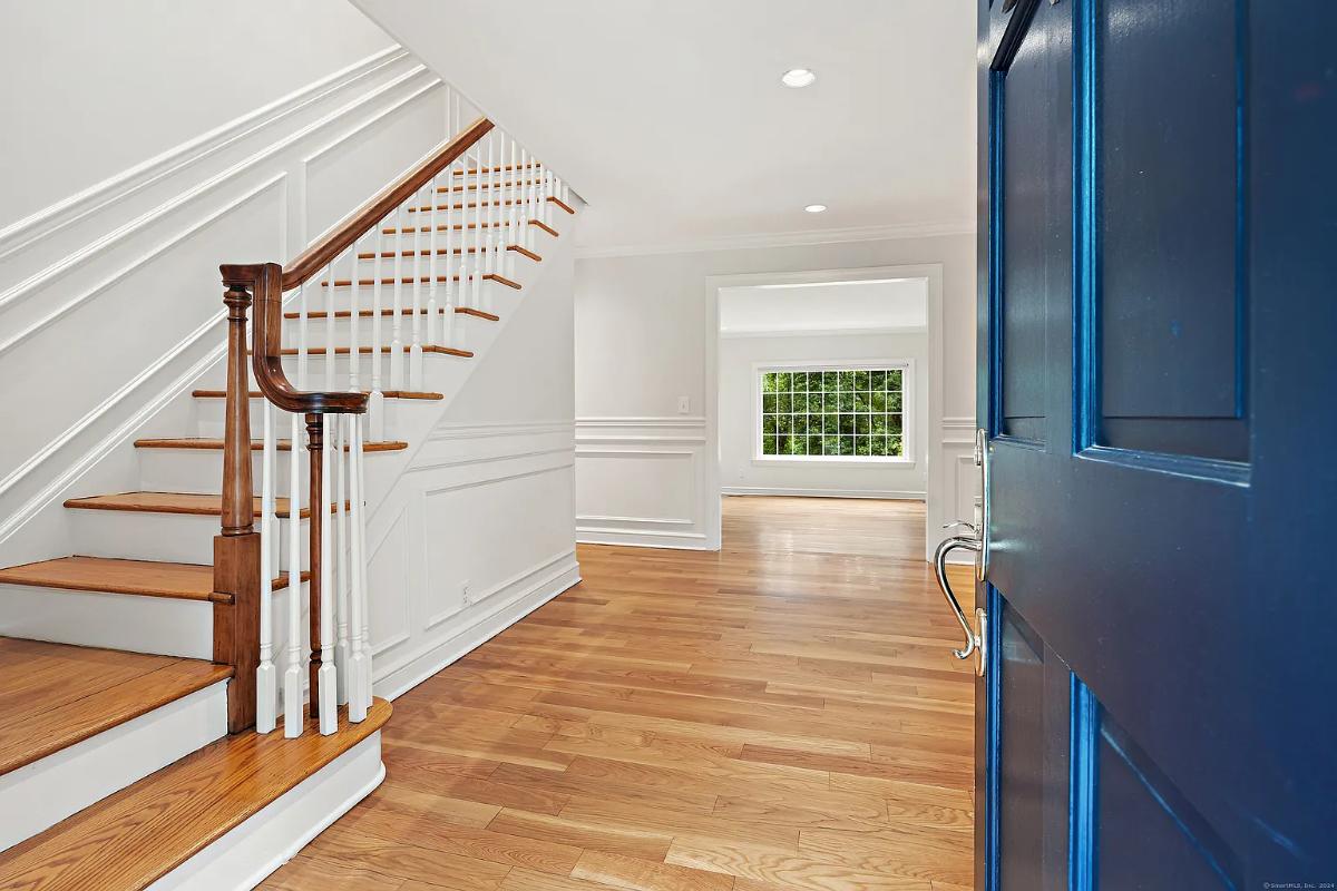 Foyer with hardwood floors and stairs.