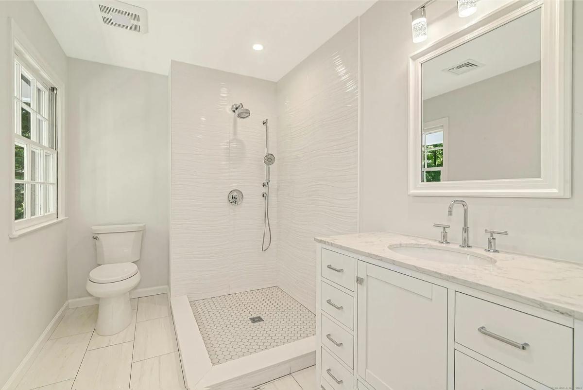 Bathroom with a sink, toilet and a walk-in shower.