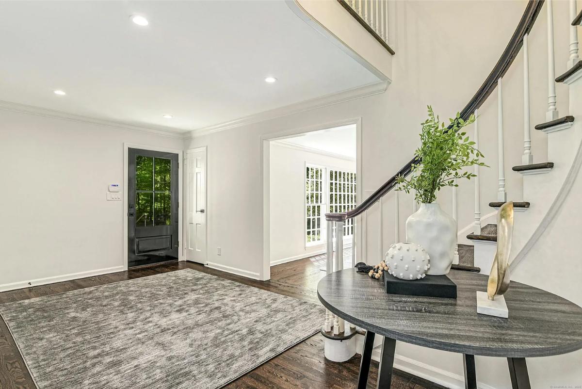Foyer with hardwood floors and stairs.