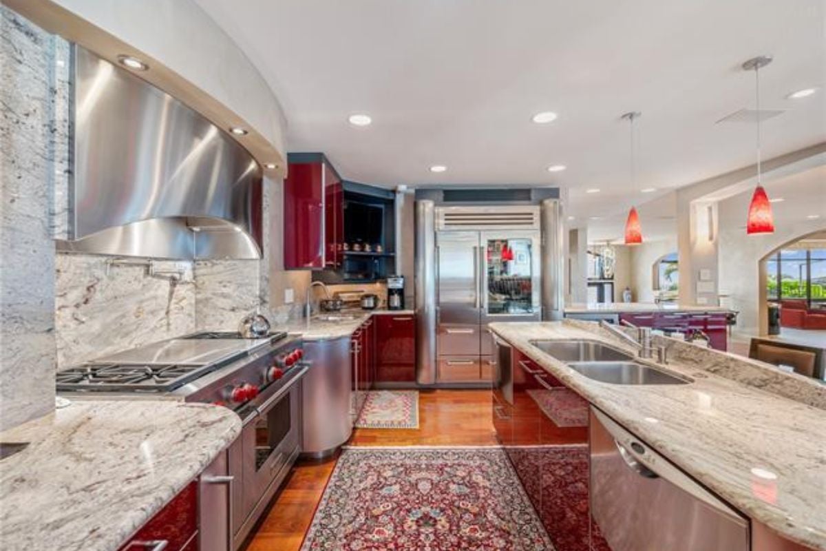 A kitchen with countertops, a sink, cabinets, and kitchen appliances.