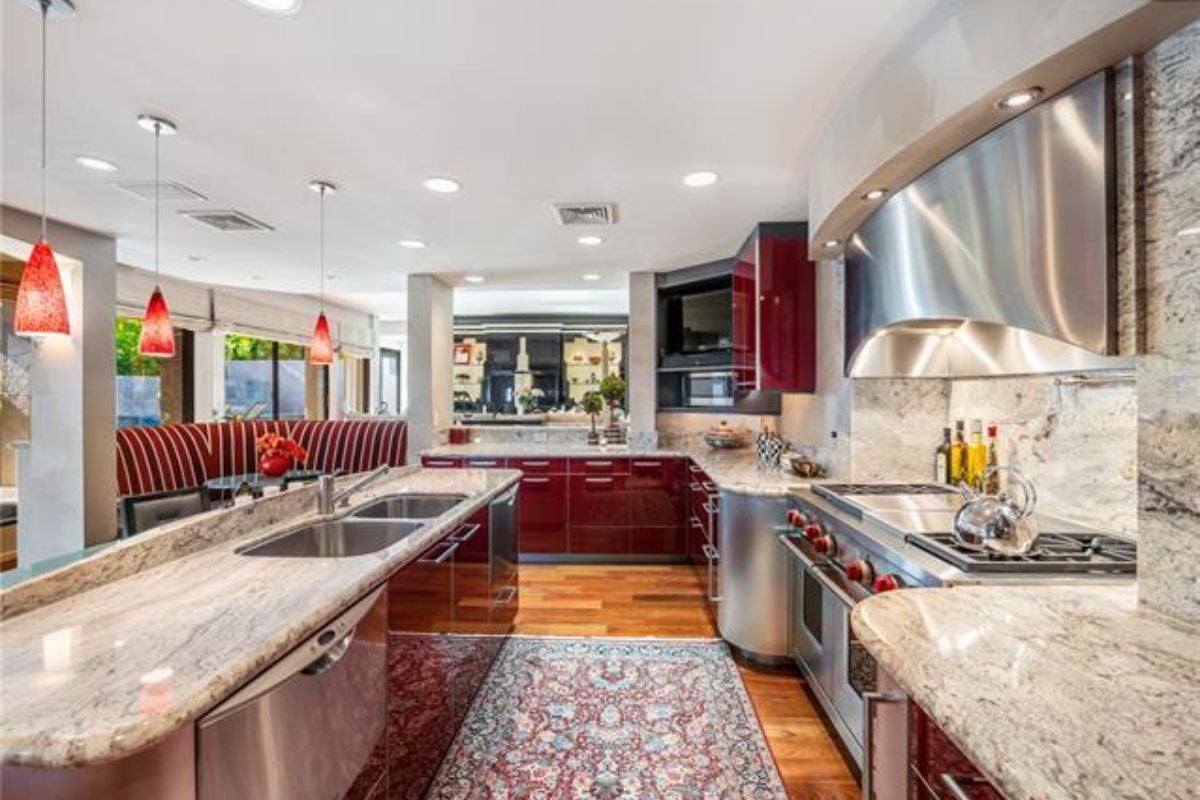 A kitchen with countertops, a sink, cabinets, and kitchen appliances.
