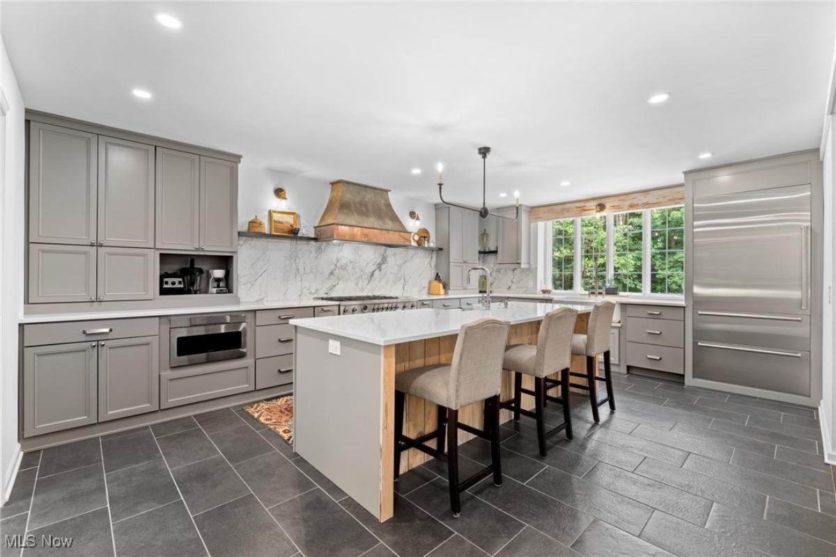 Kitchen with custom cabinetry, a counter breakfast bar and stainless-steel appliances.
