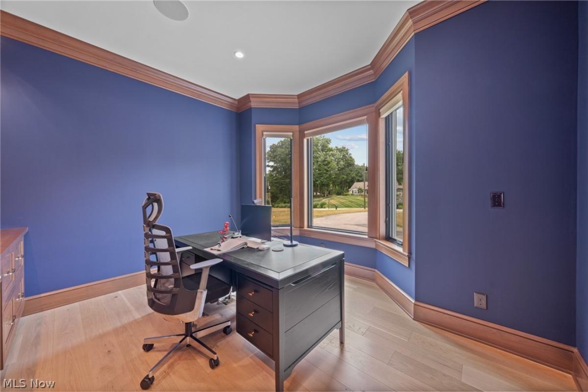 Home office with hardwood floors and glass windows.