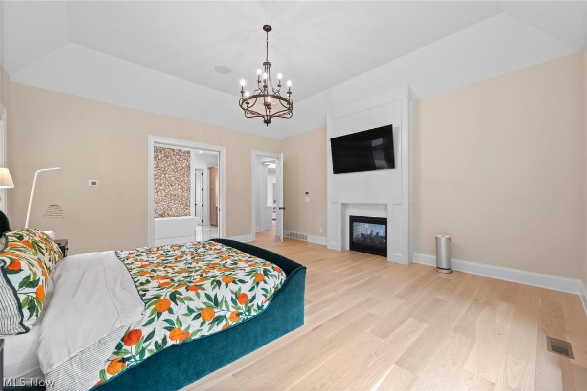 Bedroom with hardwood floors and a fireplace.