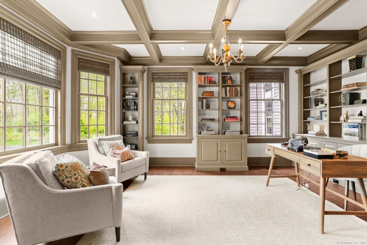 Home office with hardwood floors and coffered ceilings.