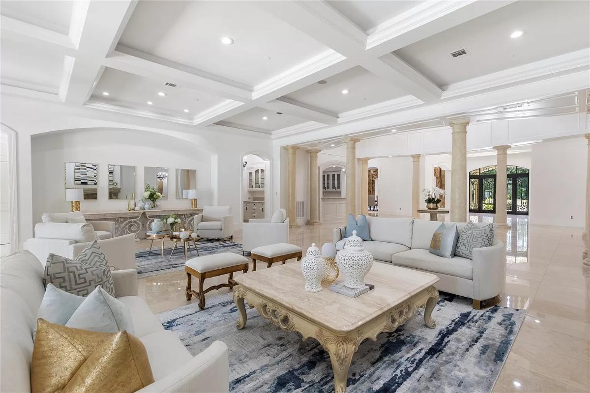 Living room with tile flooring and coffered ceilings.