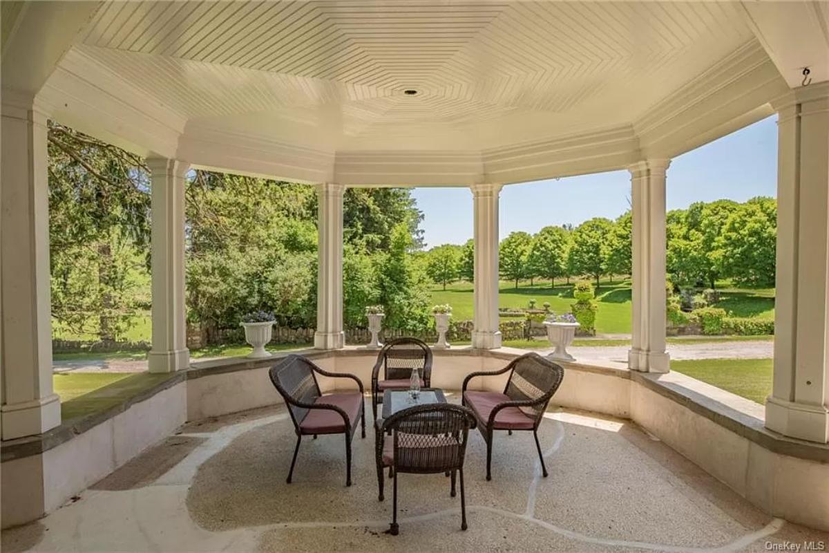Covered patio with a table and chairs.