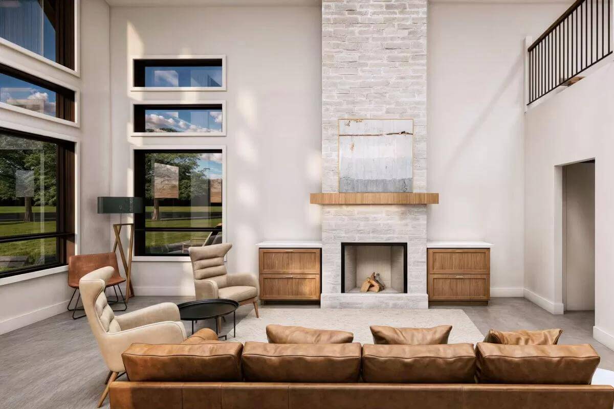 Living room with a leather sofa, wingback chairs, and a fireplace flanked by cabinets.