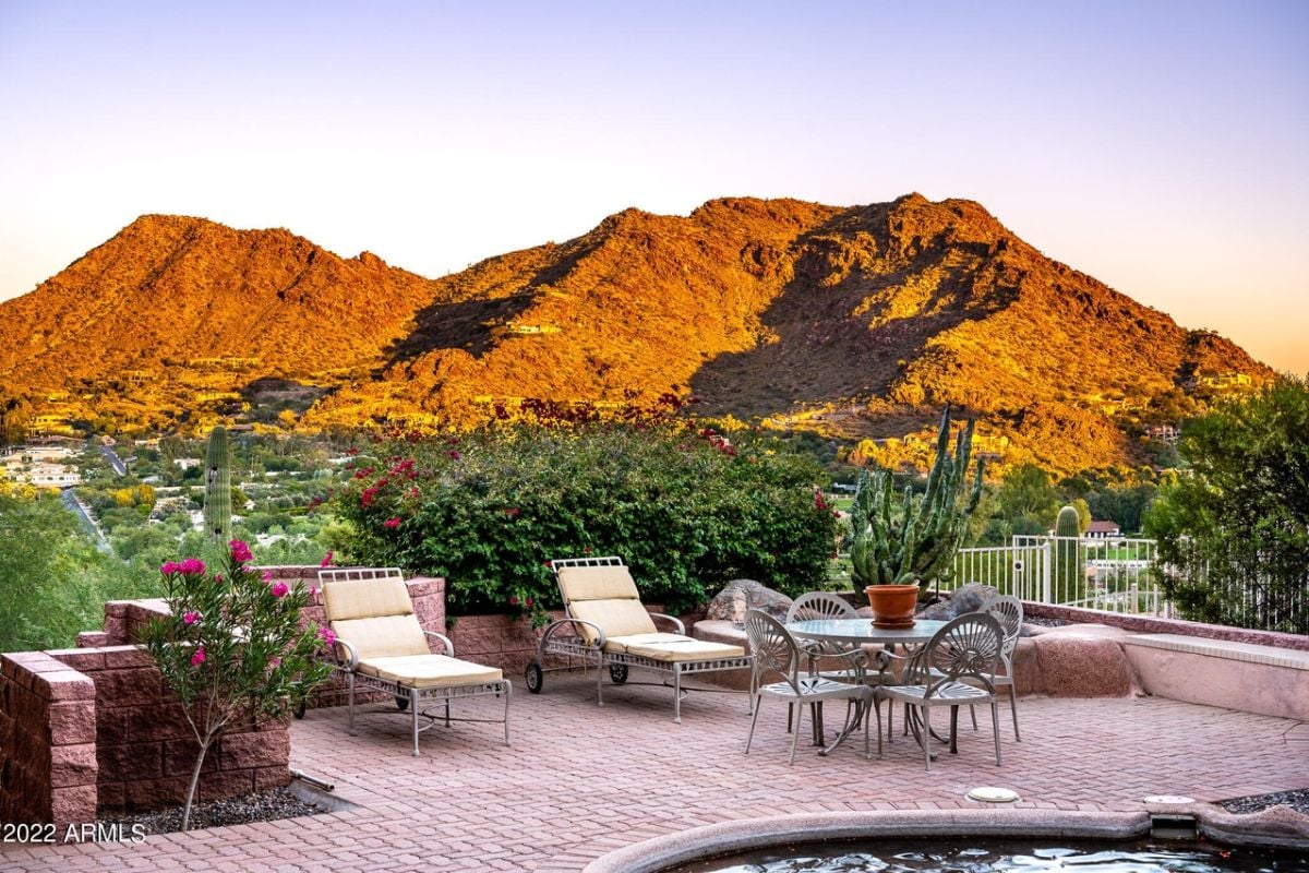 A patio with chairs, a coffee table, and plants.