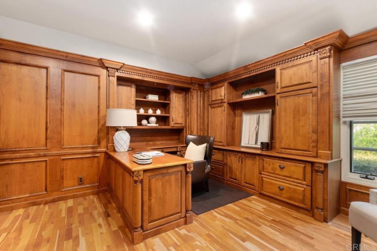 A home office with a desk, chair, and cabinets.