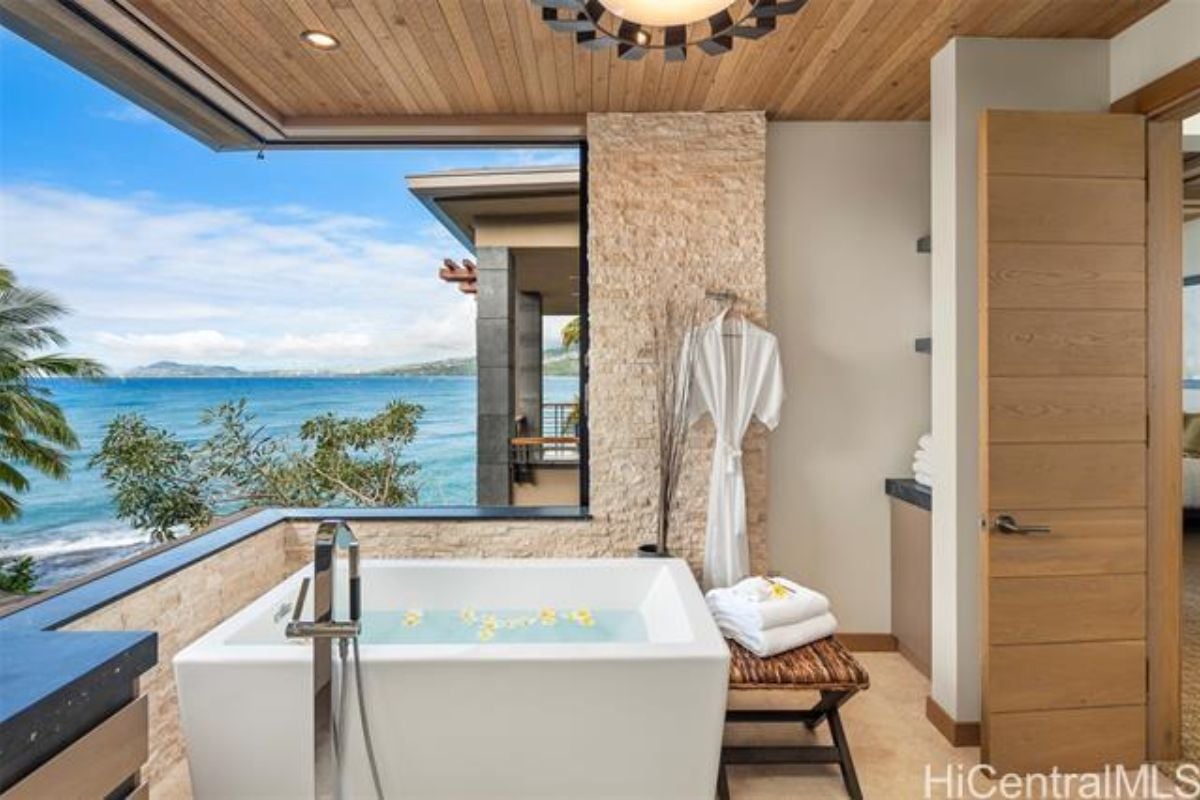 A bathroom with a window and bathtub.