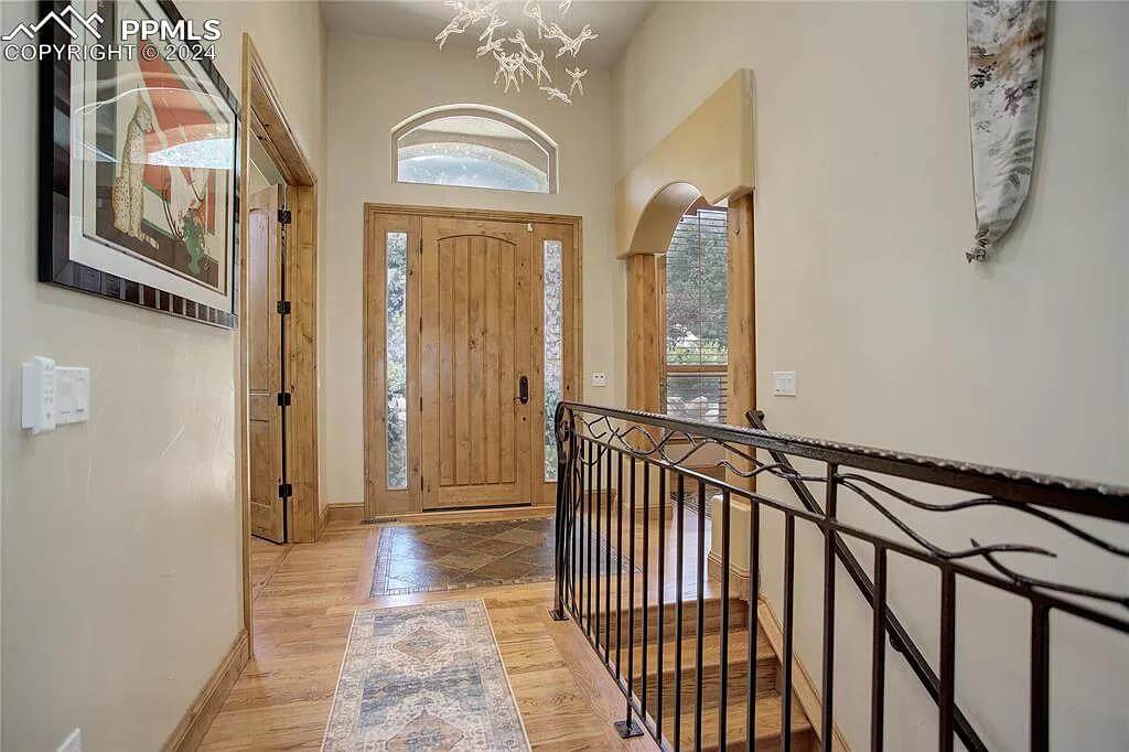 Foyer with a wooden front door topped by an arched transom.