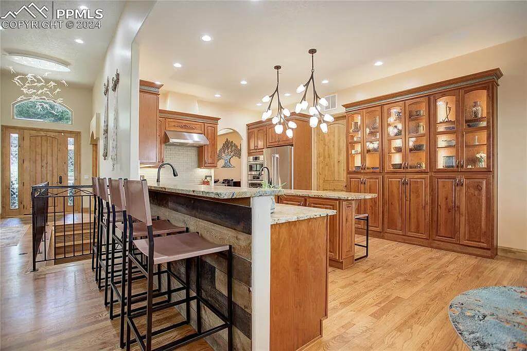 Kitchen with wooden cabinetry and a peninsula with a raised eating bar.