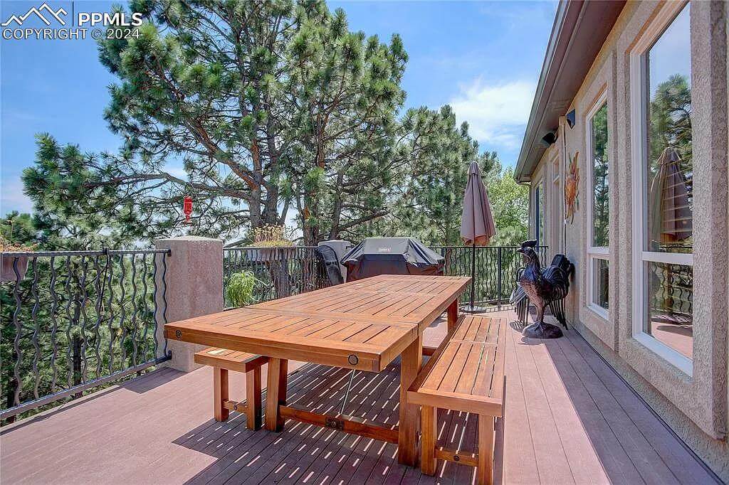 Deck with an outdoor dining and wrought iron railings.