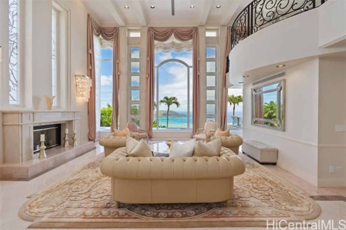 A living room with a fireplace, rug, and couches.