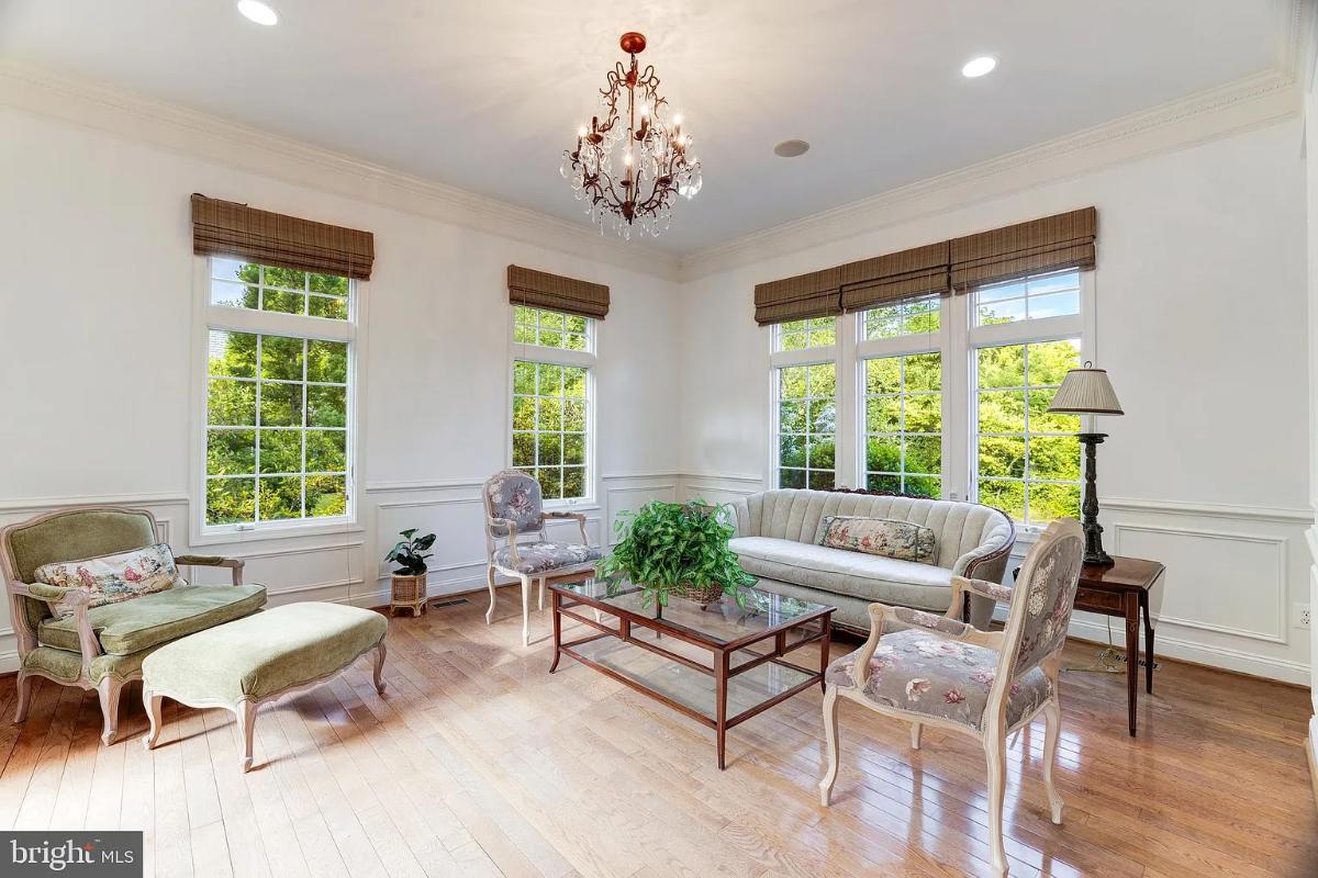 Living room with a chandelier and glass windows.