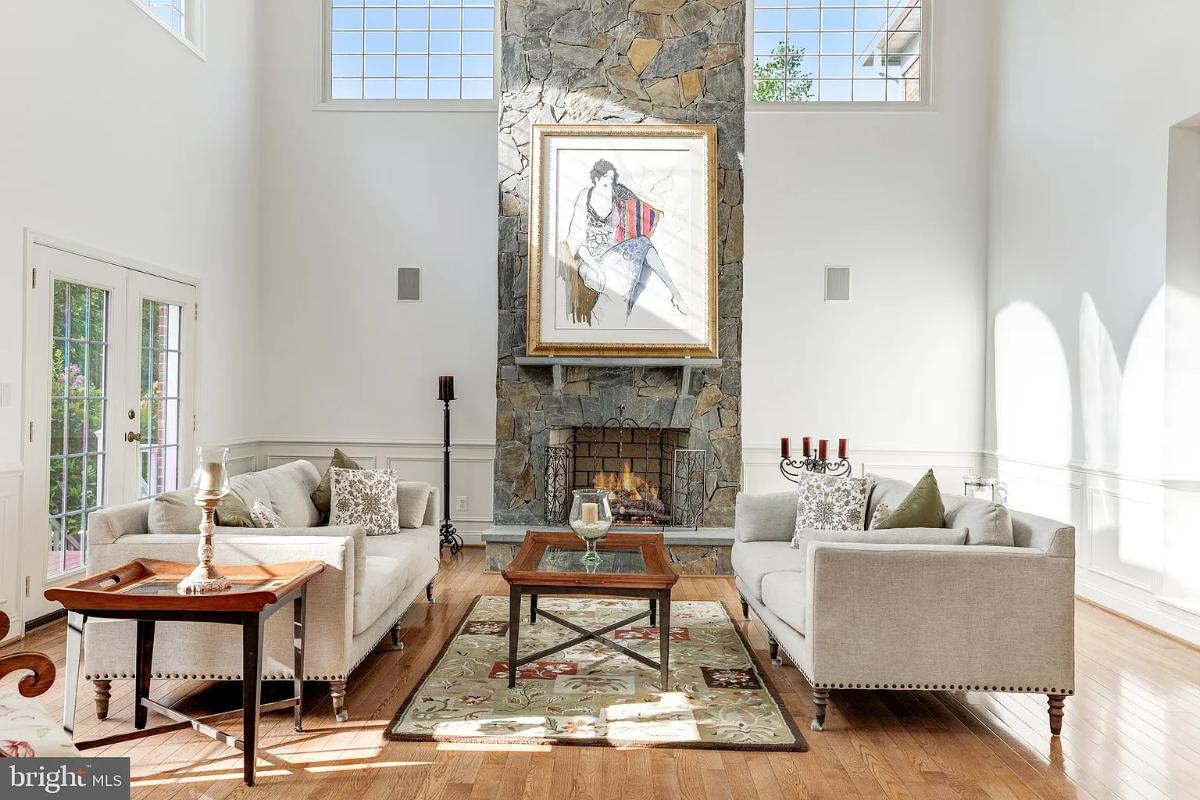Living room with high ceilings and a fireplace.