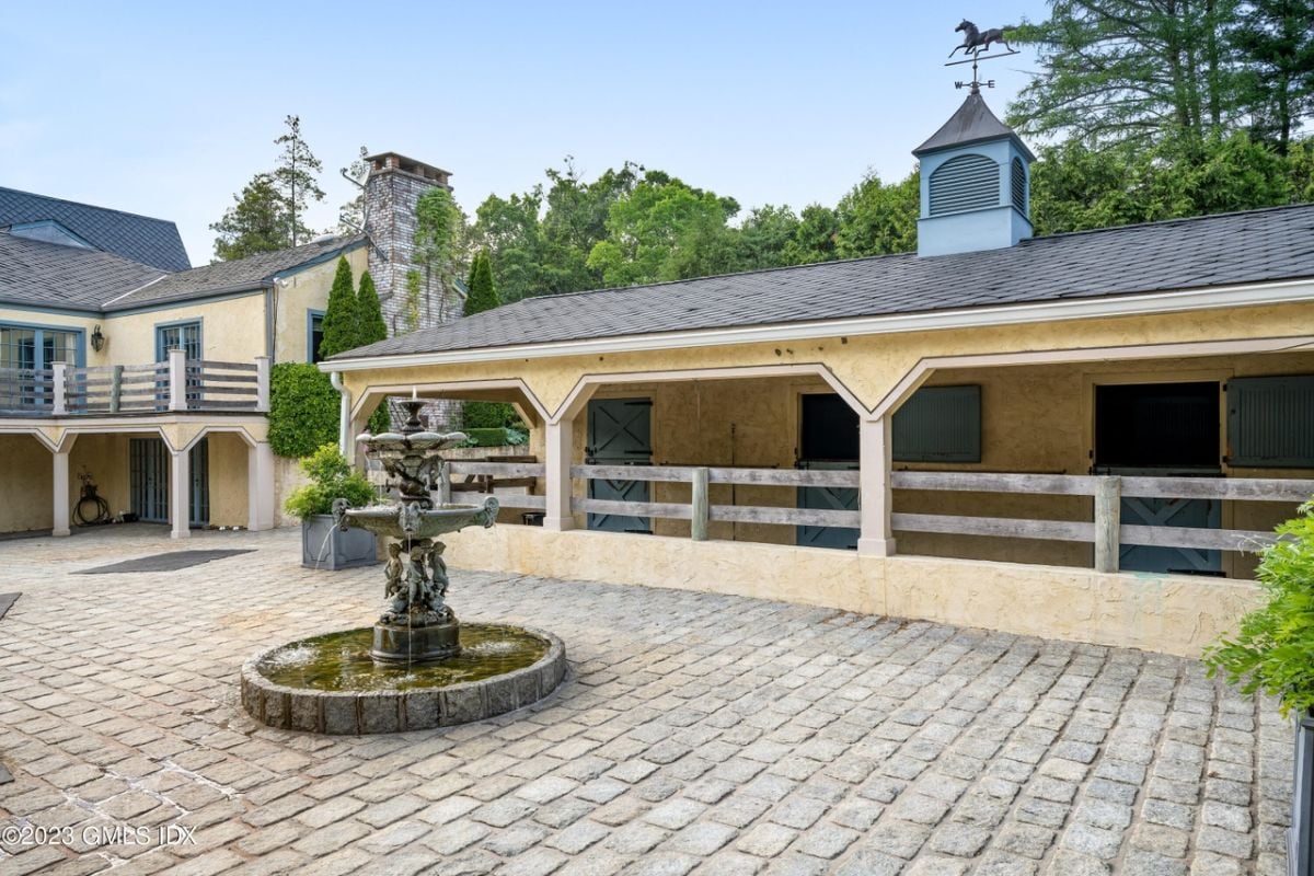 A courtyard with a brick floor and a fountain at the center.