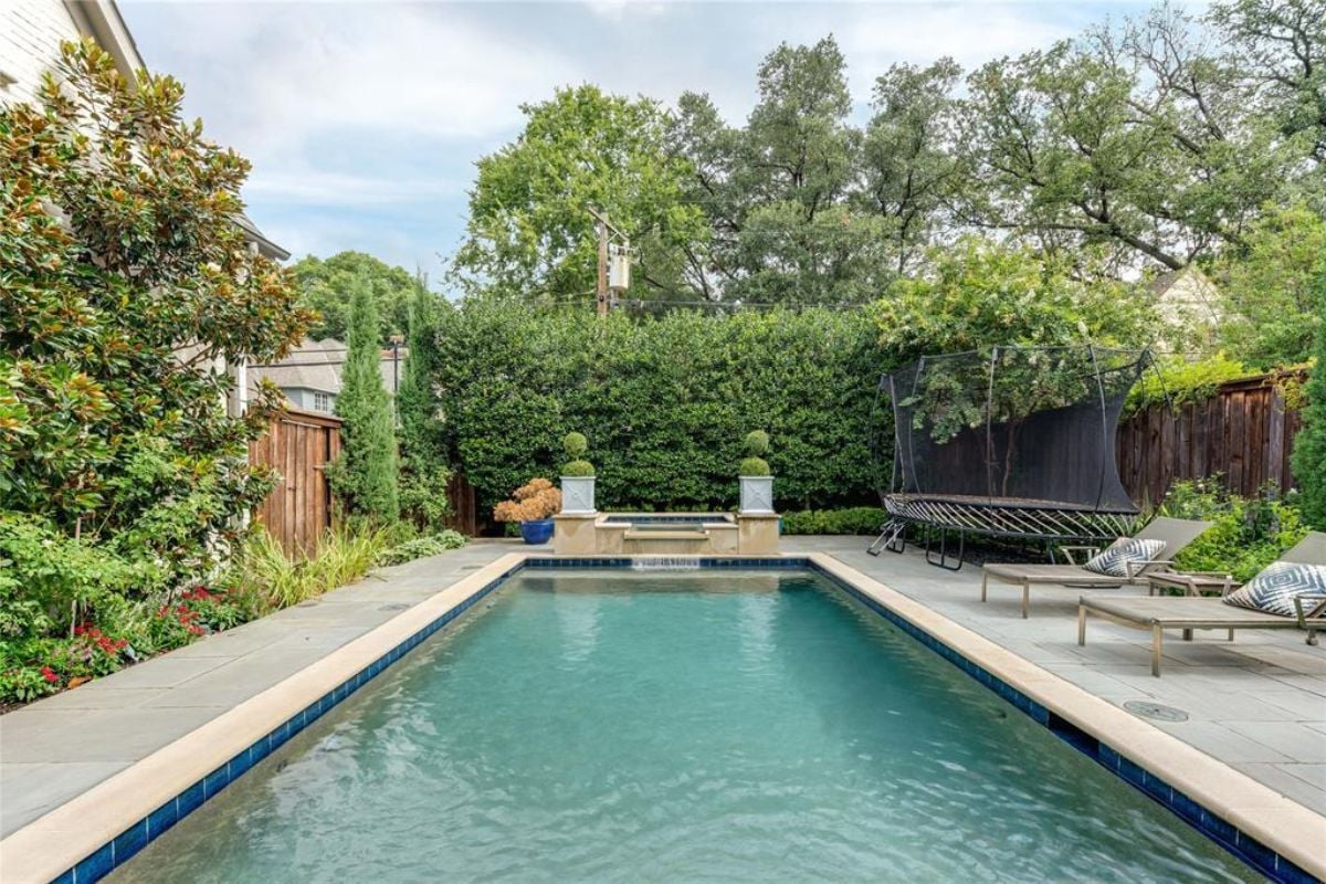 A swimming pool surrounded by plants and trees.