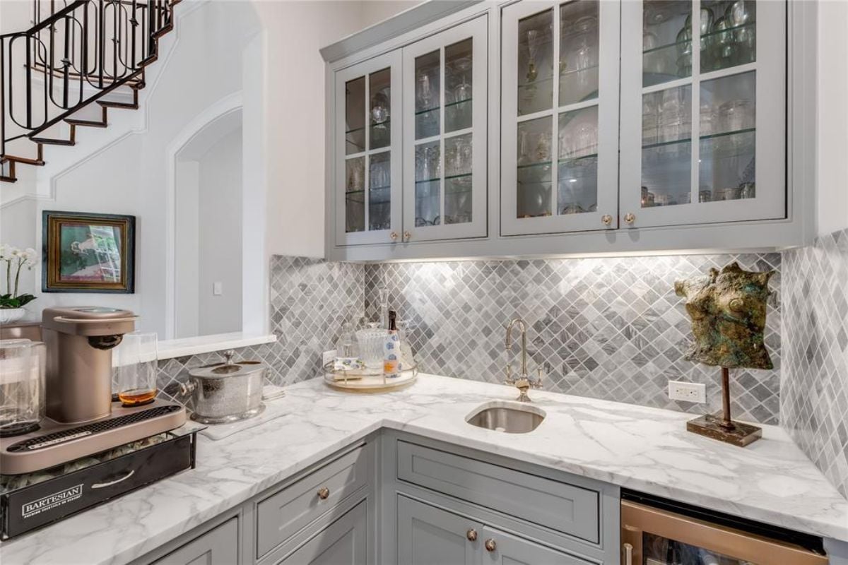 A kitchen with a countertop, cabinets, a sink, and a stove.