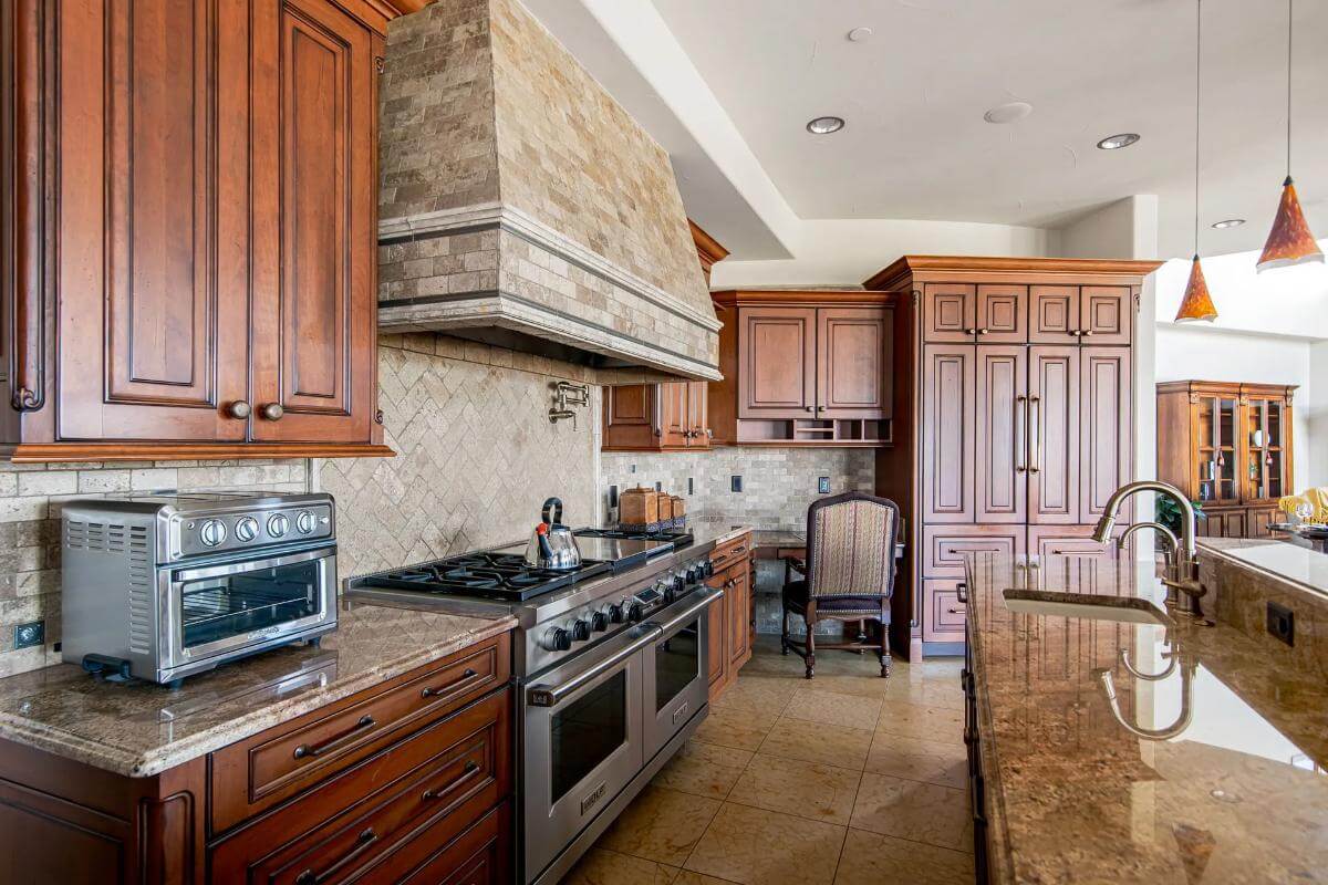 The kitchen includes a built-in desk and a prep sink fitted on the island.