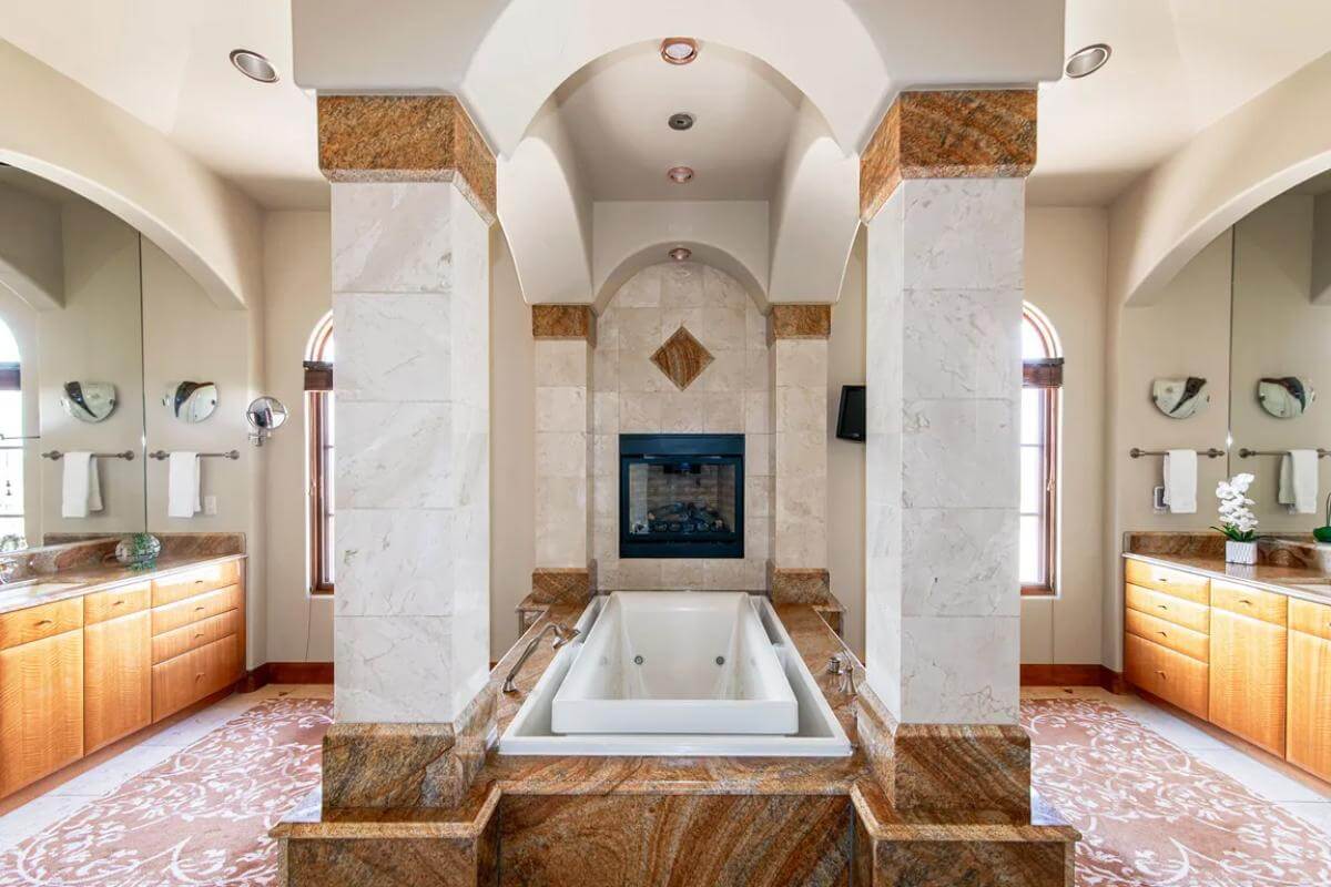 Primary bathroom with his and her vanities flanking the alcove tub.