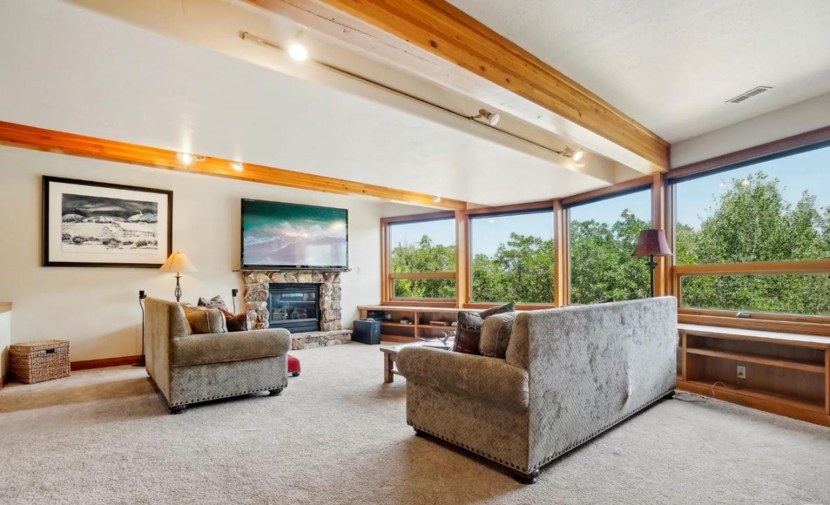 Living room with carpet flooring and a fireplace.