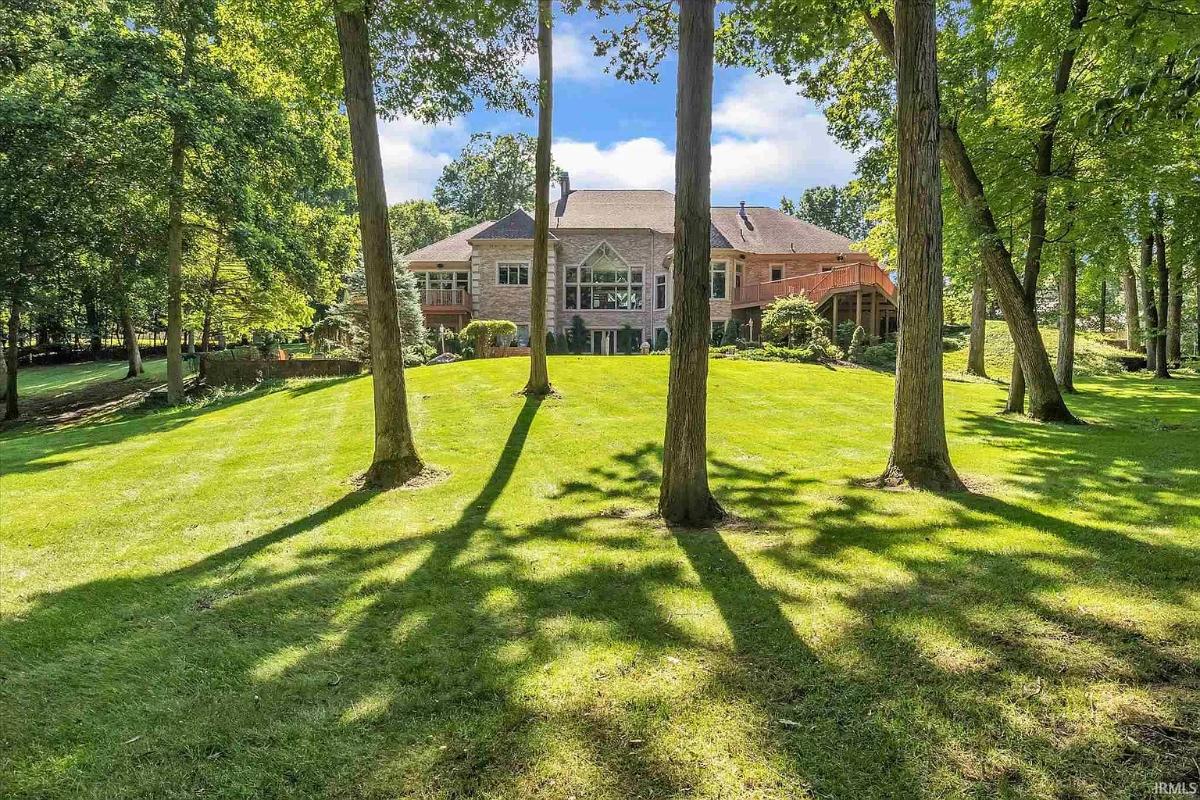 Rear view of the mansion with a large green lawn.
