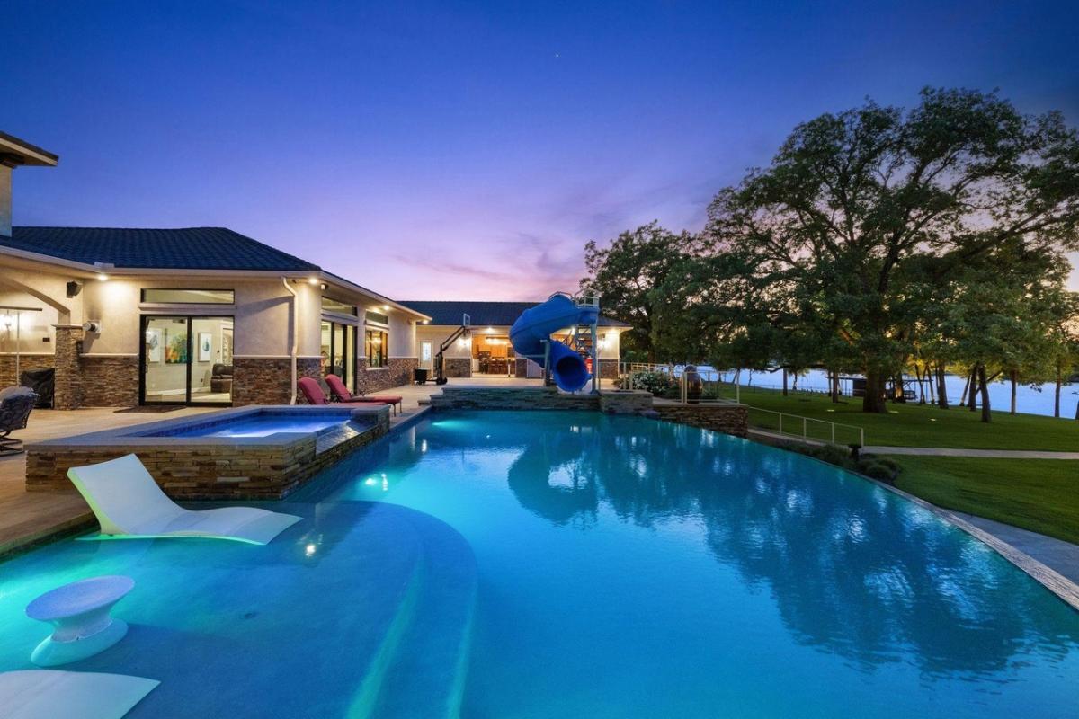Pool with lounge chairs and a slide.