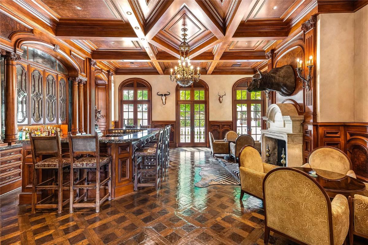 Bar with coffered ceilings and a fireplace.