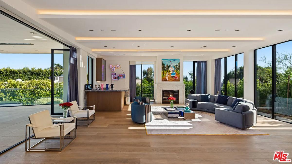 Living room with hardwood floors, couches and a fireplace.
