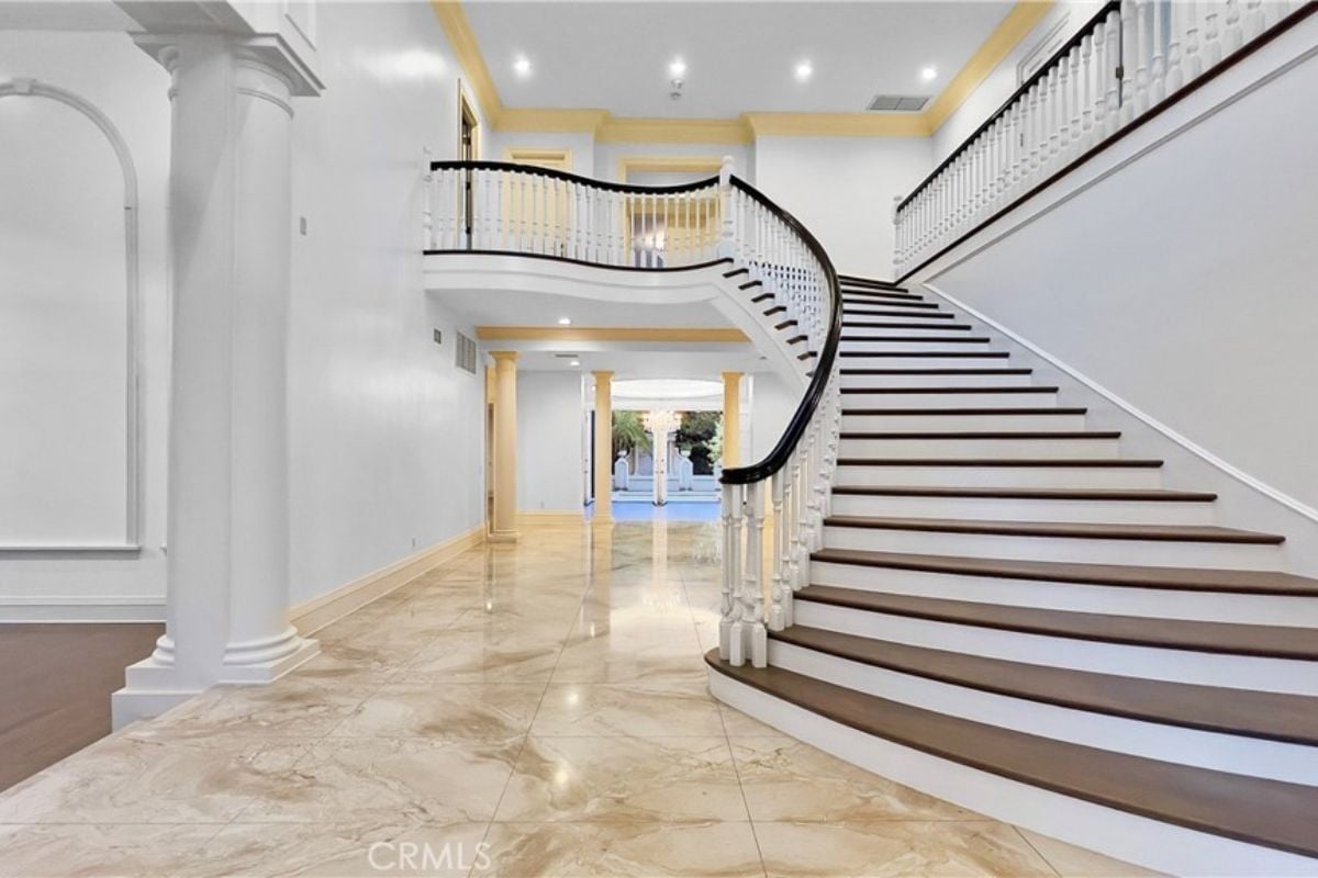 A foyer with a tiled floor and a staircase.