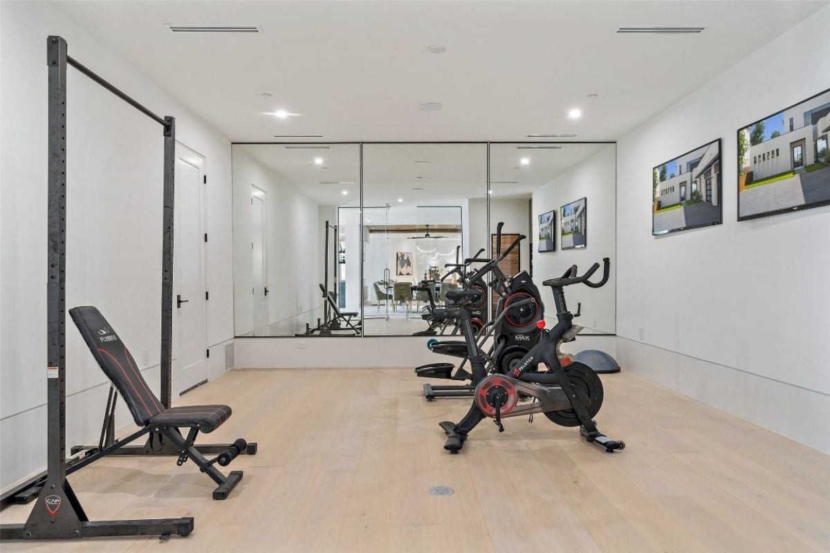 A home gym with a mirror and gym equipment.