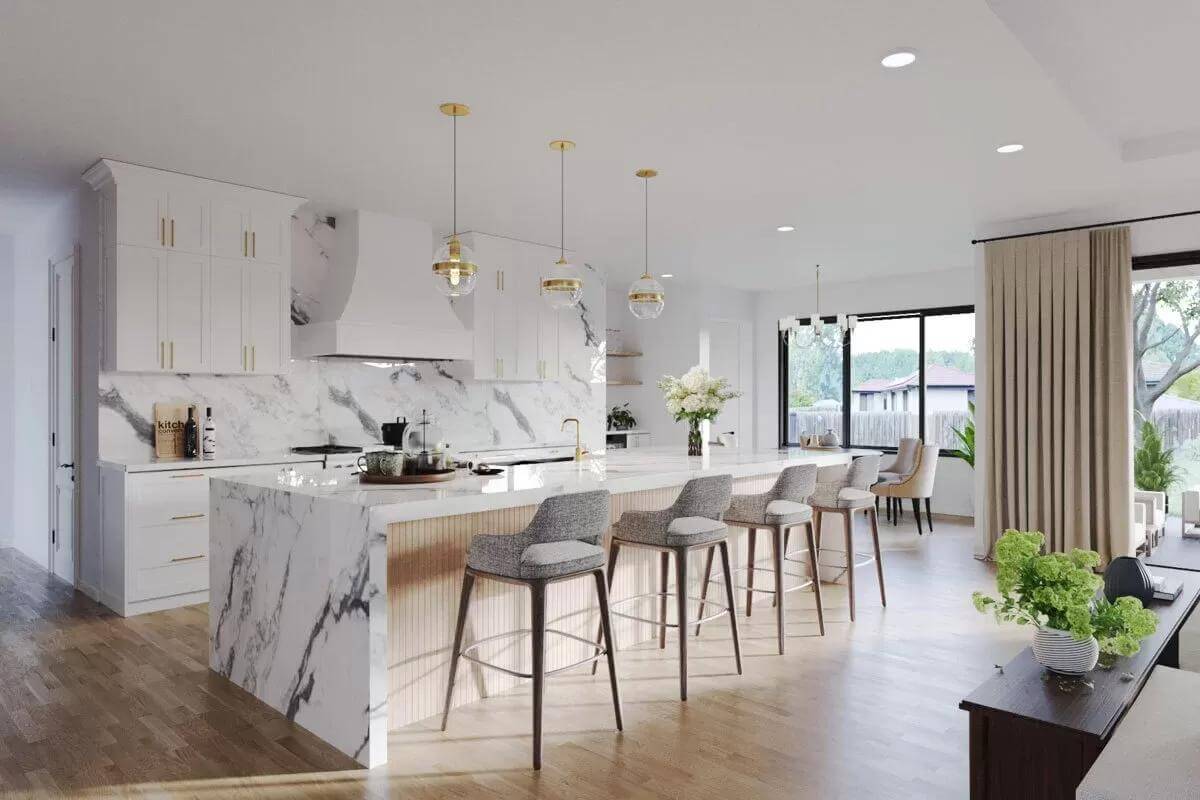 Kitchen with white cabinetry and a waterfall island topped by brass pendants.