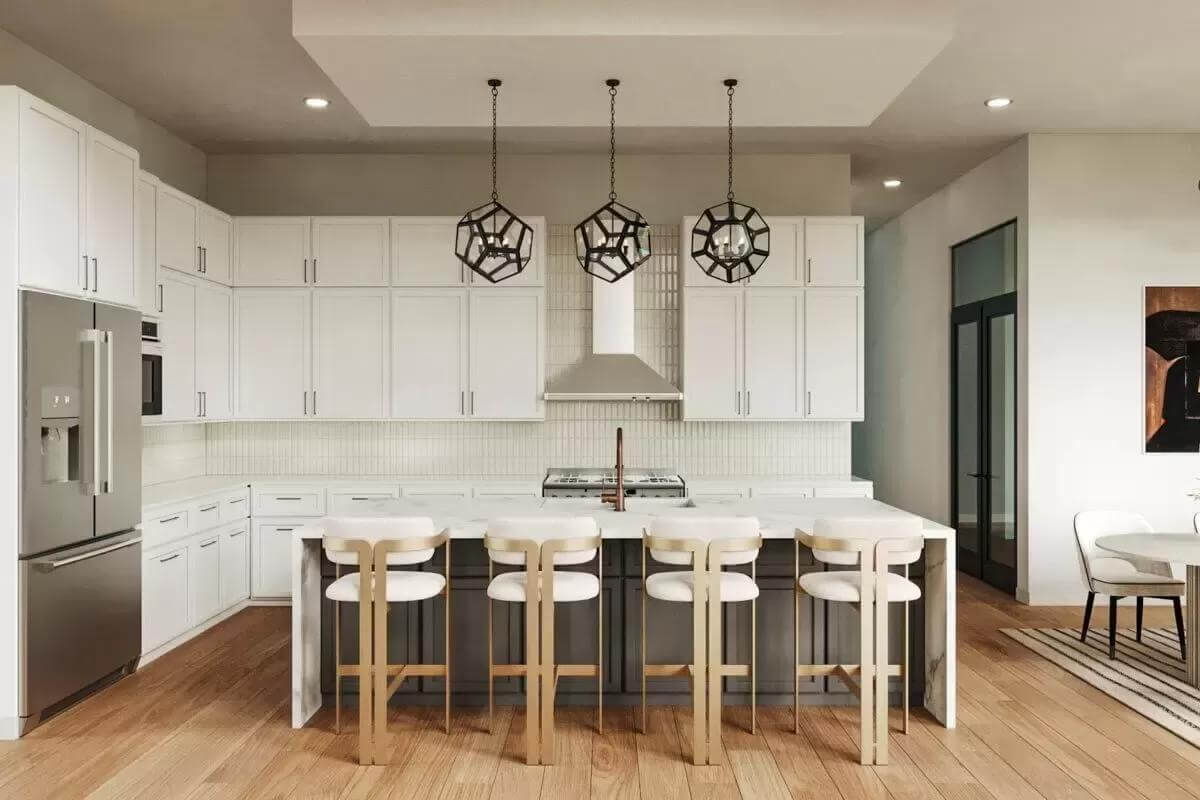 Kitchen with white cabinetry and a waterfall island topped by wrought iron pendants.