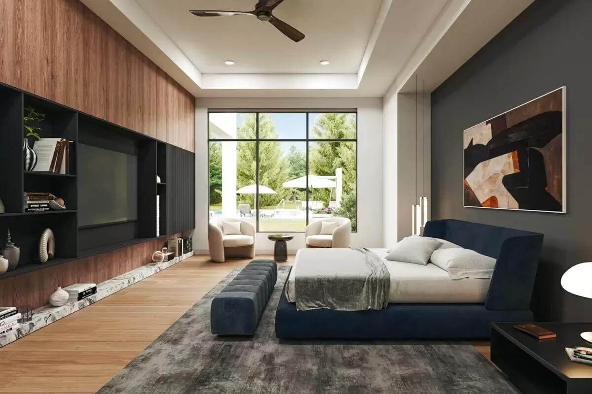 Primary bedroom with a wall-mounted TV, a sitting area, a tray ceiling, an upholstered bed, and a matching bench.