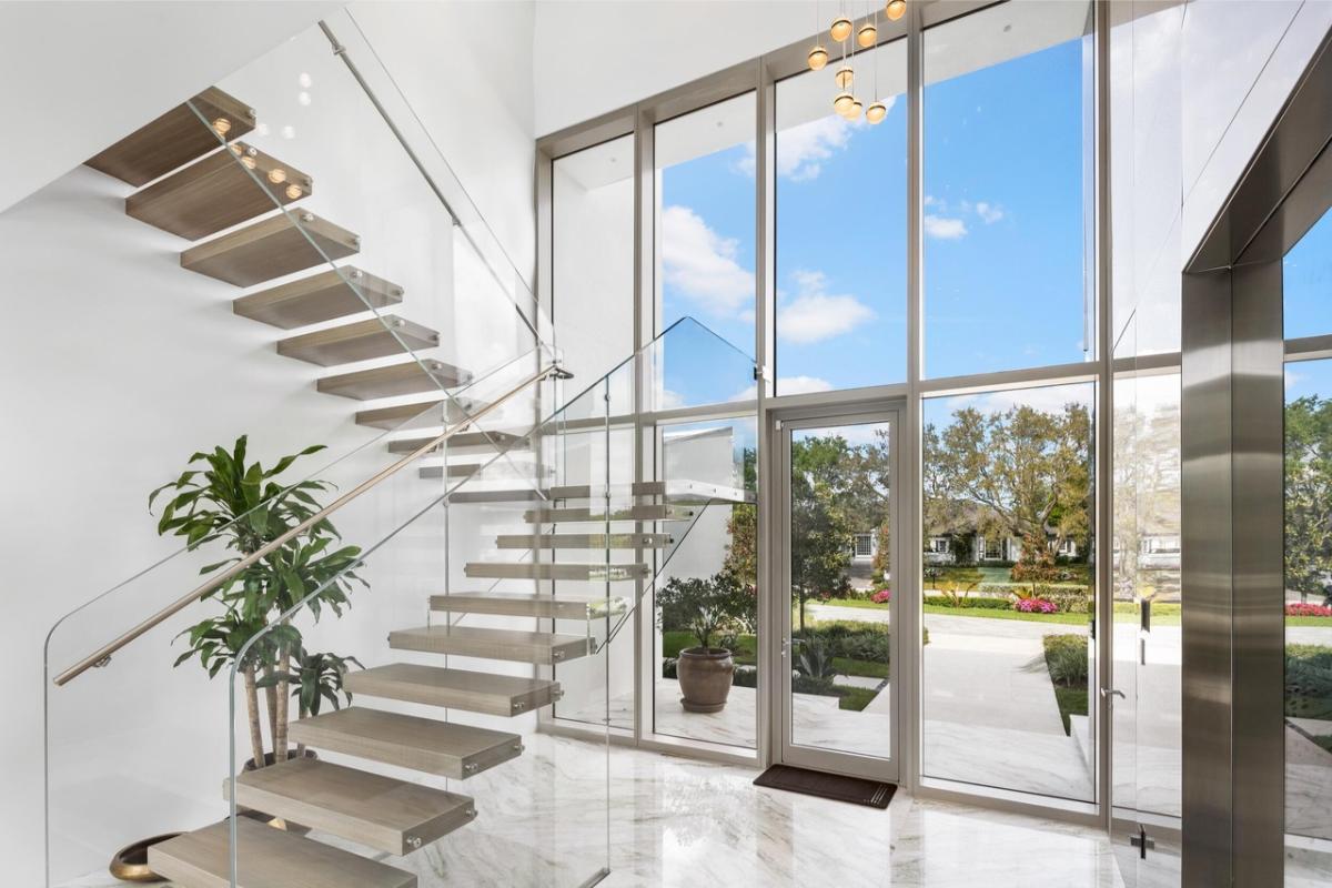 Foyer with glass walls, glass doors and stairs.