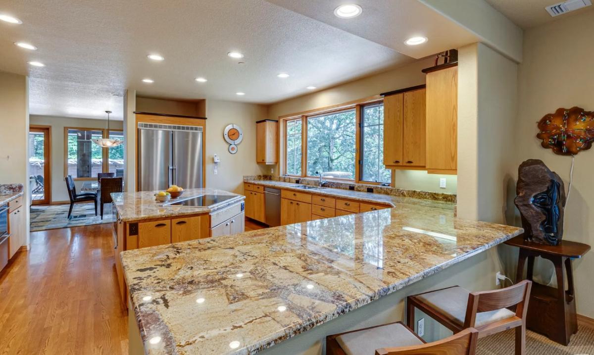 Kitchen with custom cabinetry, a counter breakfast bar and a center island prep area.