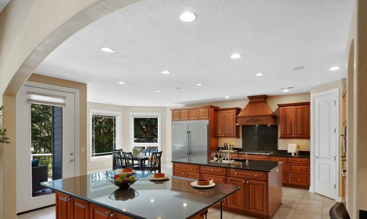 Kitchen with custom cabinetry, a counter breakfast bar and a center island prep area.