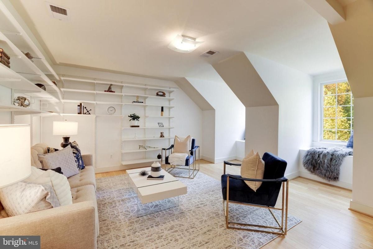 A family room with shelves, a couch, chairs, and a coffee table.
