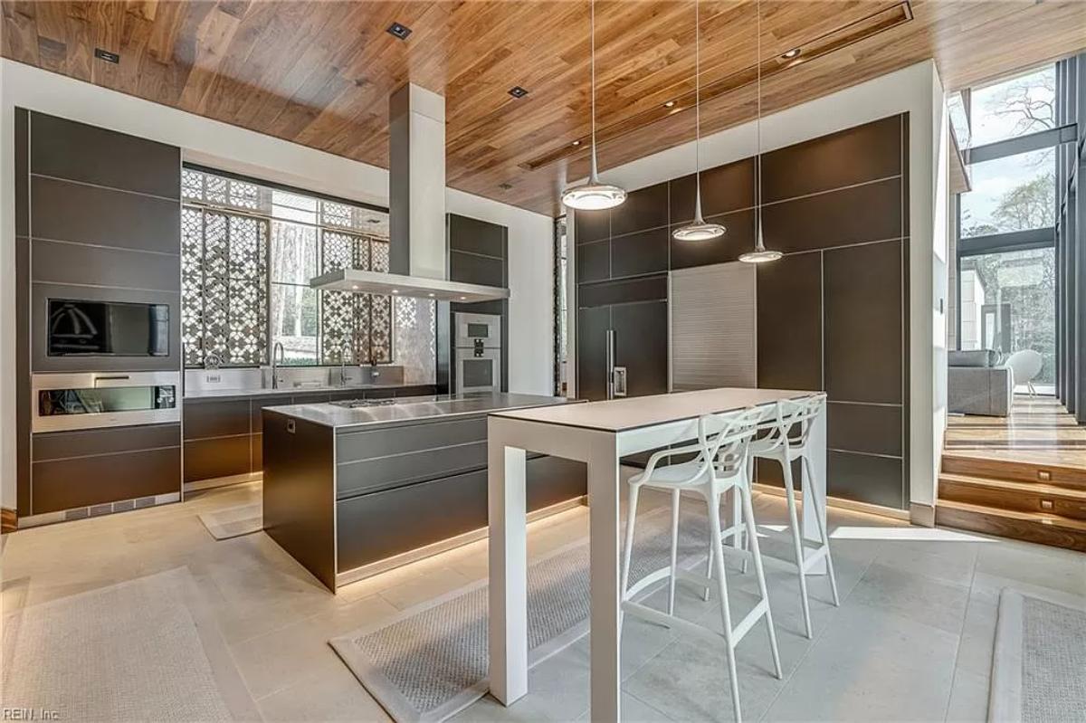 Kitchen with custom cabinetry, a counter breakfast bar and a center island prep area.