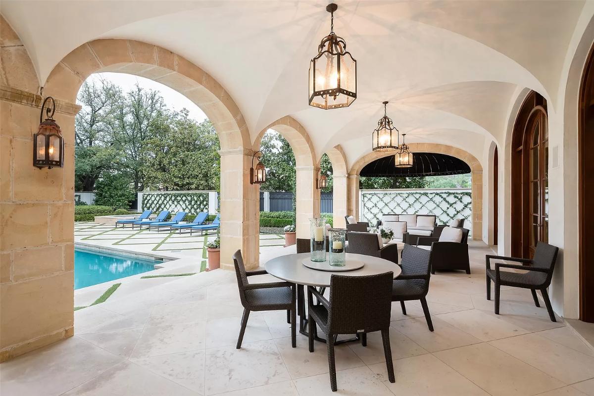 Covered patio with a dining table and a living space.