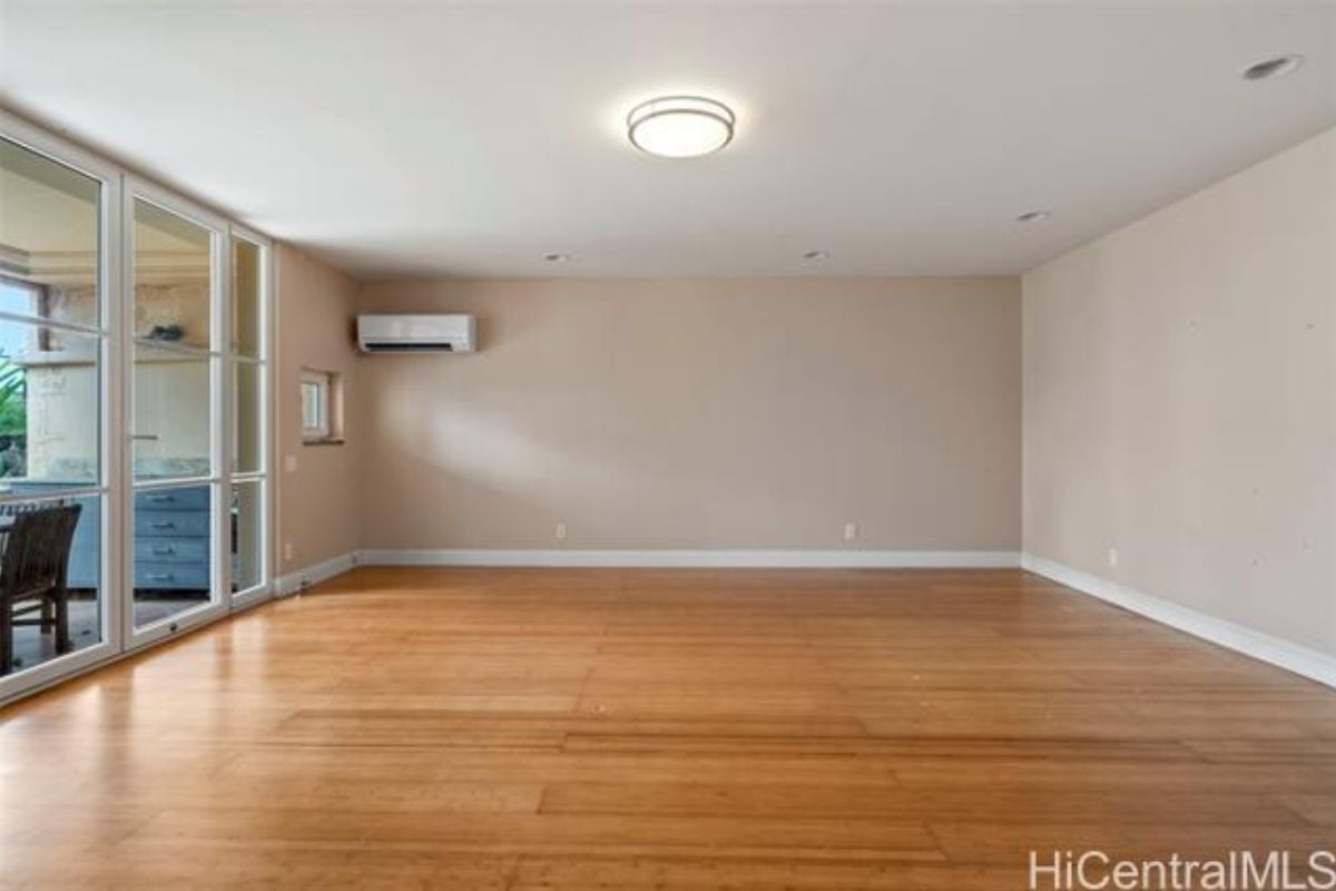An empty bedroom with wooden floors.