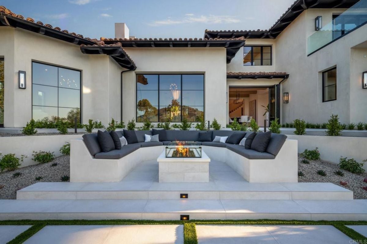 A patio with a firepit surrounded by a U-shaped bench.