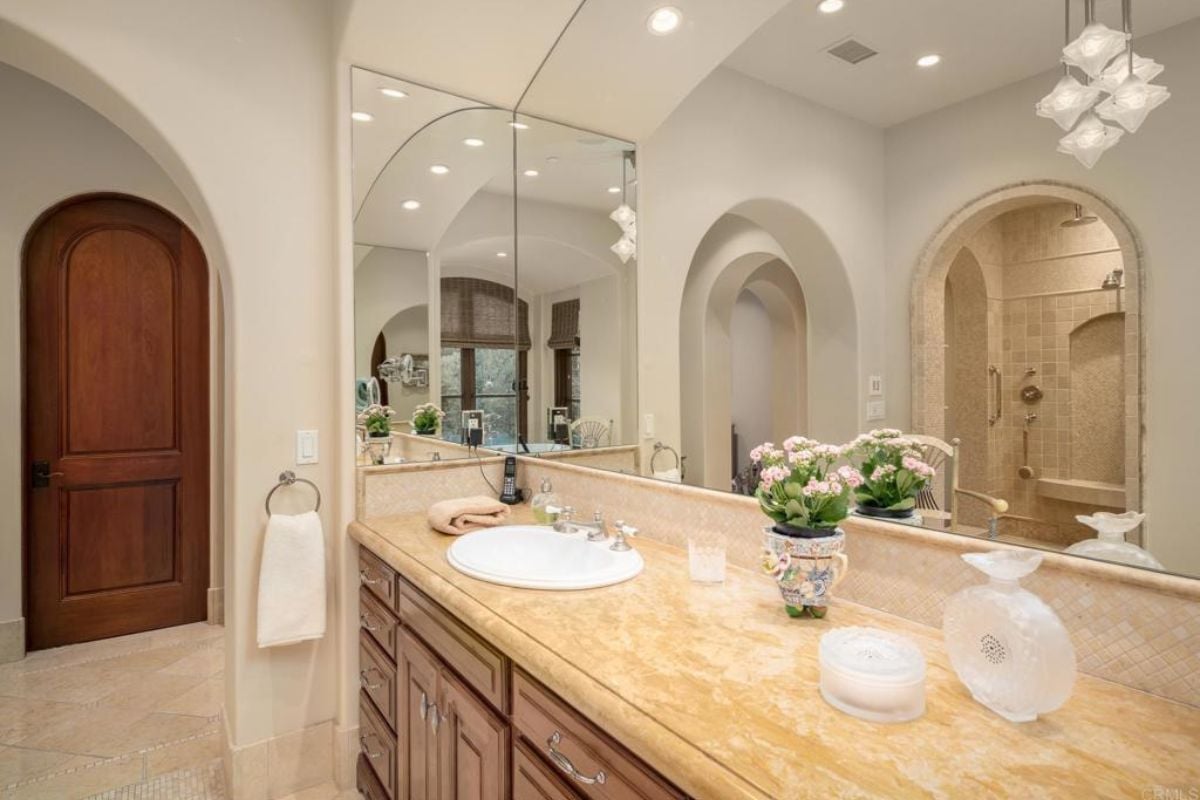 A bathroom with a vanity, a mirror, and a cabinet.