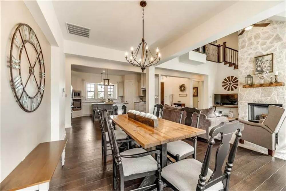 Dining room with a rectangular dining set illuminated by a warm chandelier.