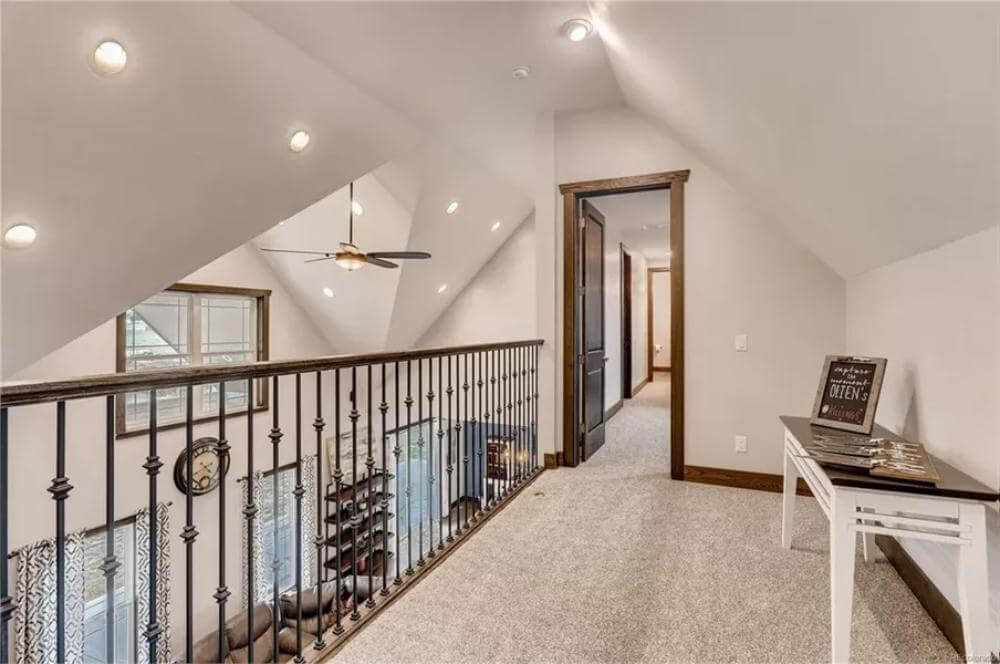 Balcony with a wrought iron railing and a console table over the carpeted floor.