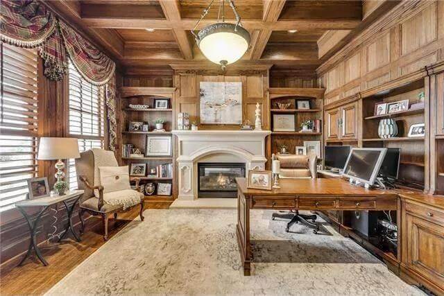 Study with a fireplace, wood-paneled walls, and a matching coffered ceiling.