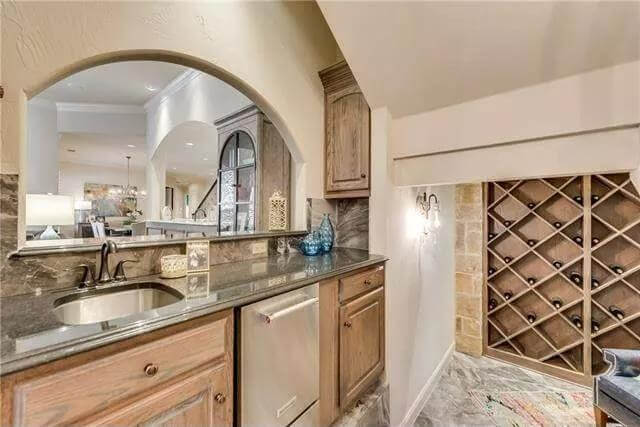 Wine cellar with built-in racks and a wet bar.
